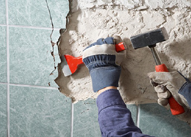 Проведение демонтажа плитки. Если материал необходим для дальнейшего использования, его нужно демонтировать максимально осторожно.