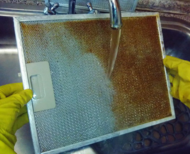 Процесс очистки фильтра от жира. Можно его предварительно оставить в горячей мыльной воде на некоторое время, чтобы грязь легче удалялась.