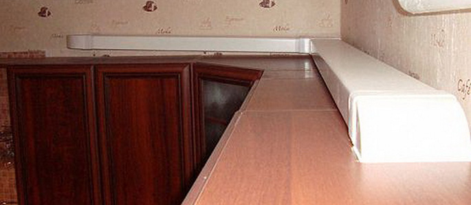 Плоский воздуховод вытяжки на кухне менее заметен, если его расположить вдоль стены над шкафами